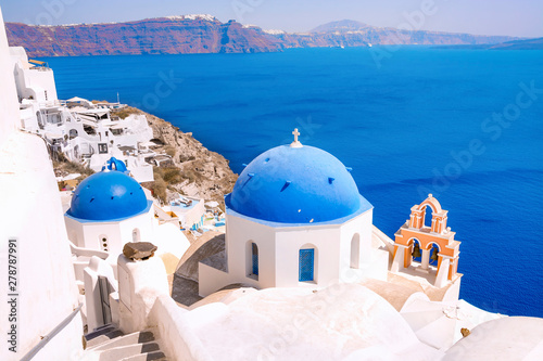 Beautiful village of Oia with traditional white houses and blue domes of the church in Santorini island, Greece