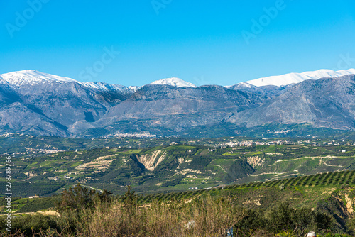Aerial view of rural Heraklion region landscape. Unique alpine scenic panorama Olive groves, vineyards, green meadows and hills in spring. Psiloritis montains in background. Heraklion, Crete, Greece