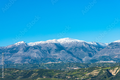 Aerial view of rural landscape in Heraklion. Unique alpine scenic panorama Olive groves, vineyards, green meadows and hills view in spring. Psiloritis montain in background. Heraklion, Crete, Greece