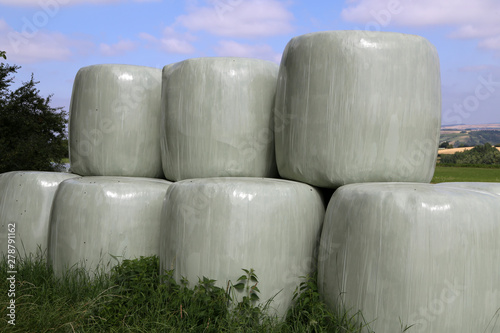 Countryside field with hay bale wrapped in plastic photo