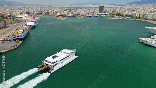 Aerial drone photo of high speed passenger catamaran ferry approaching in low speed iconic port of Piraeus, Attica, Greece