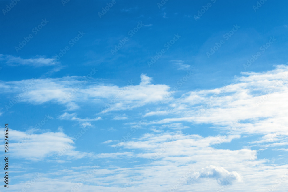 fleecy clouds on an azure sky. beautiful nature background. dynamic side lit cloudscape