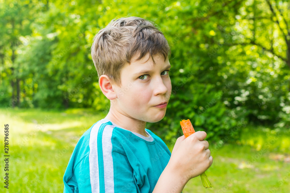 teen boy with a carrot in a forest teen boy with a carrot in a forest
