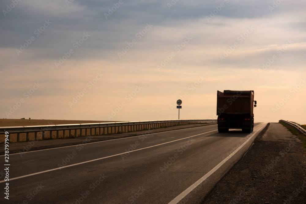 Truck driving on the asphalt road rural landscape