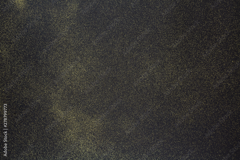 Obraz premium Golden glitter on the black background. Black glitter texture christmas abstract background. Top view, selective focus. 