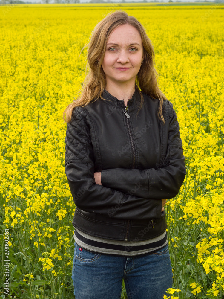Portrait of young woman on yelllow cole field background Portrait of young woman on yelllow cole field background