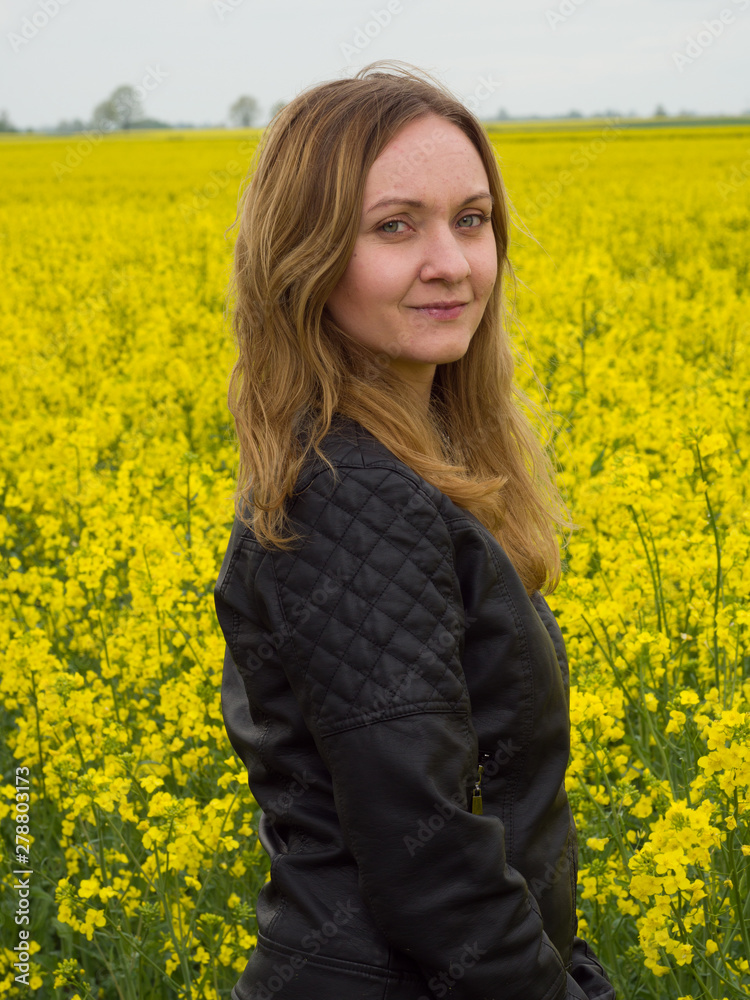 Portrait of young woman on yelllow cole field background Portrait of young woman on yelllow cole field background
