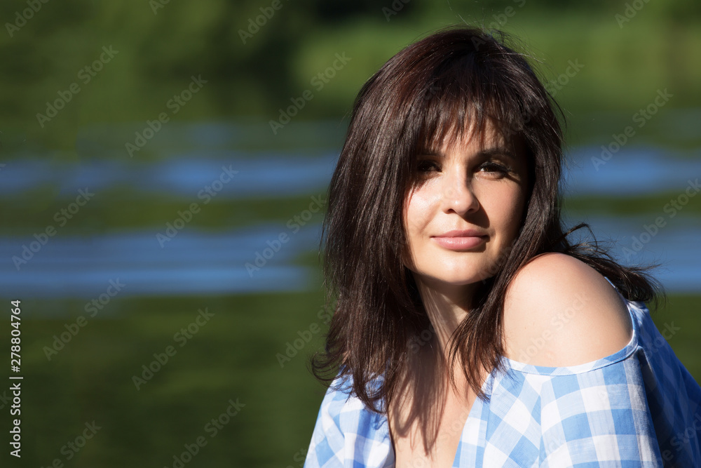 Close up portrait of a woman with dark dissolved hair. She looks at the viewer and smiles. Close up portrait of a woman with dark dissolved hair. She looks at the viewer and smiles.