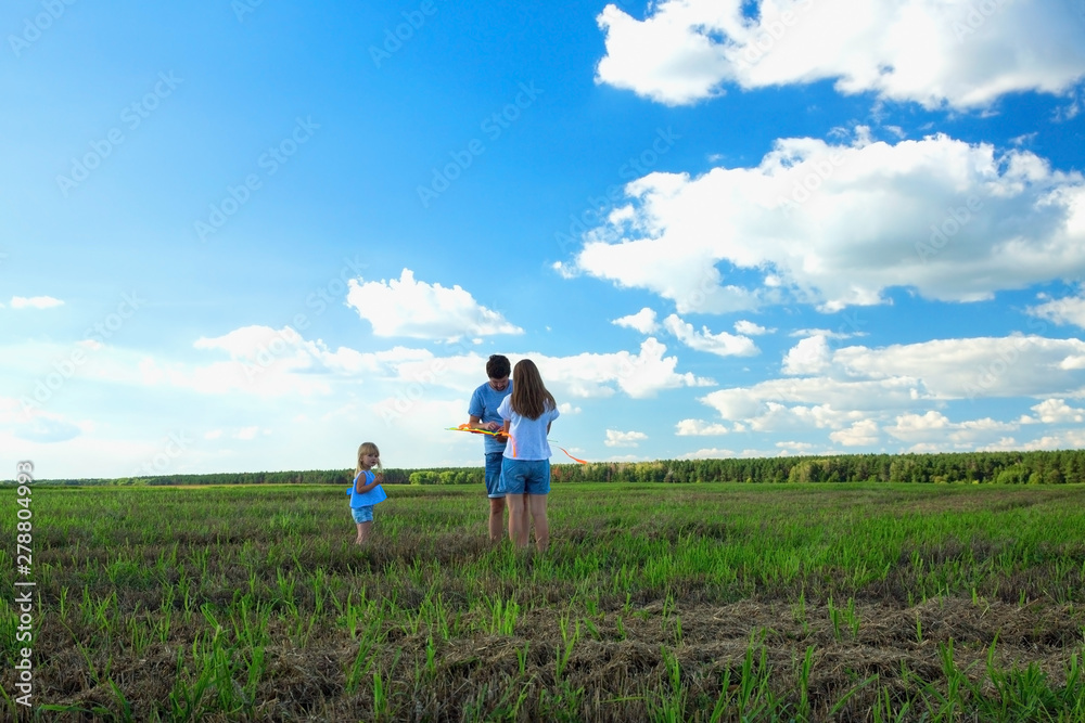 Family is flying a kite in a field