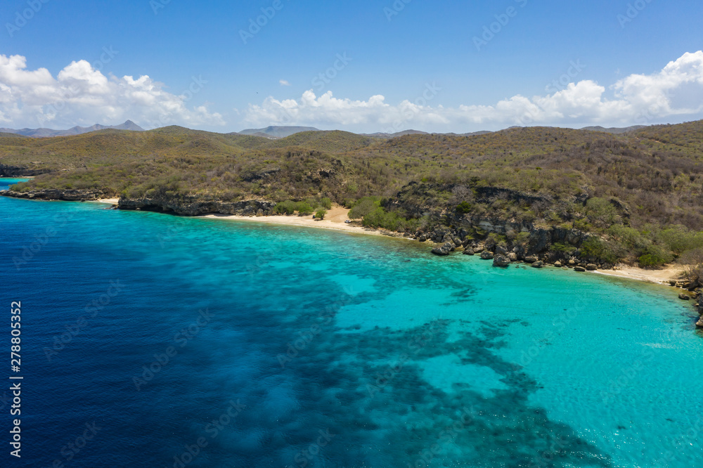 Aerial view of coast of Curaçao in the  Caribbean Sea with turquoise water, white sandy beach and beautiful coral reef at Playa Manzalina 
