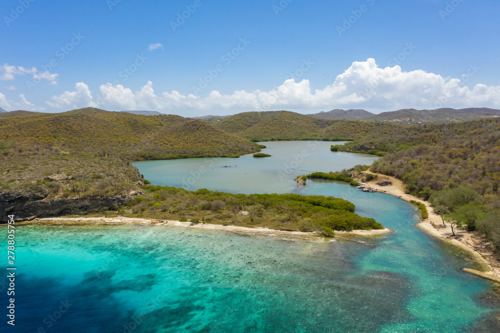 Aerial view of coast of Curaçao in the  Caribbean Sea with turquoise water, white sandy beach and beautiful coral reef at Playa Manzalina 