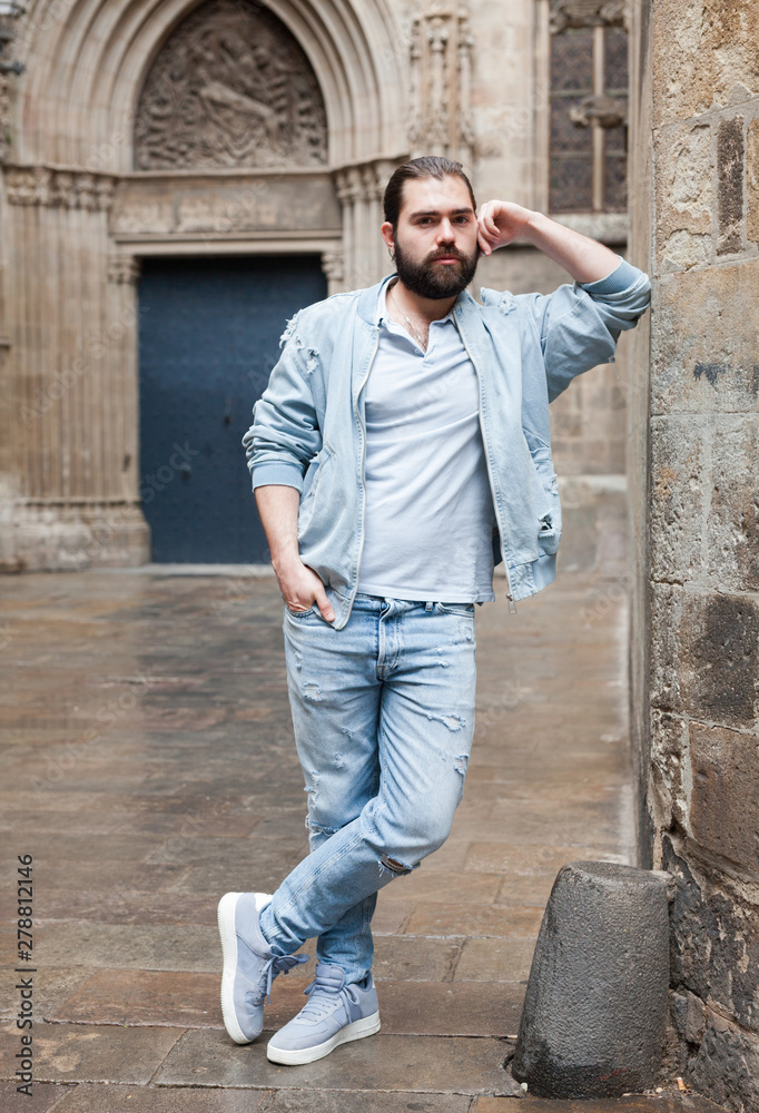 Obraz premium Handsome adult man with a beard in a jeans jacket
