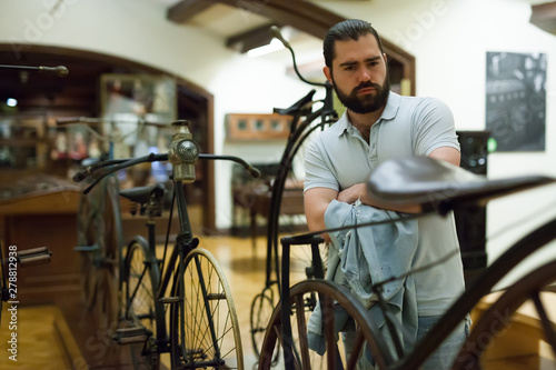 Attentive adult man exploring artworks in glass case in museum