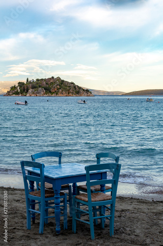 Traditional greek tavern with wooden tables on sandy beach near water waiting for tourists in Tolo, Peloponnese, Greece © barmalini