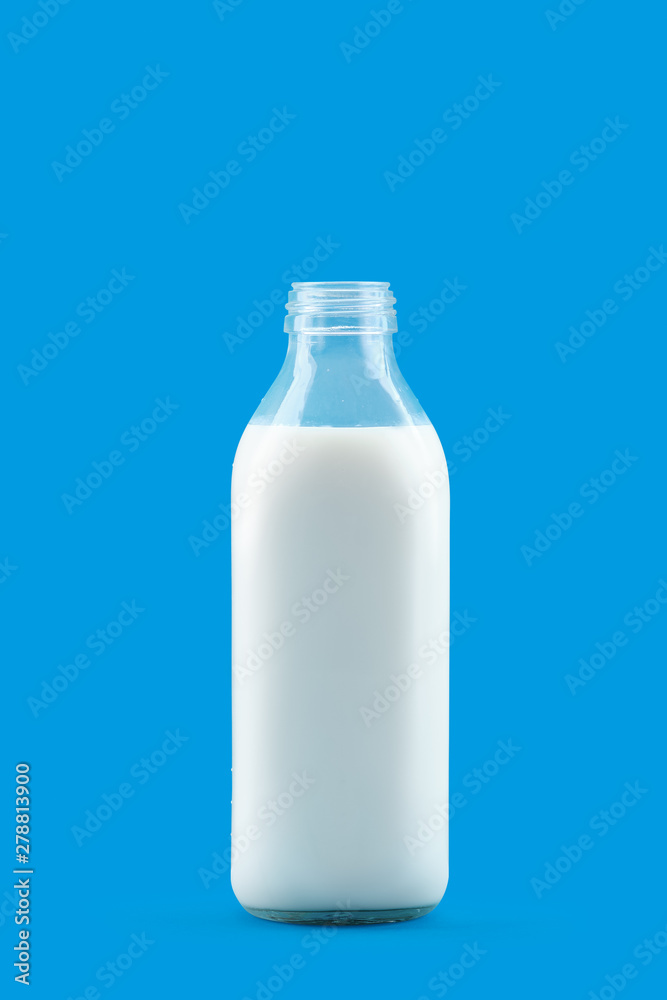 Open bottle of milk isolated on blue background Open bottle of milk isolated on blue background