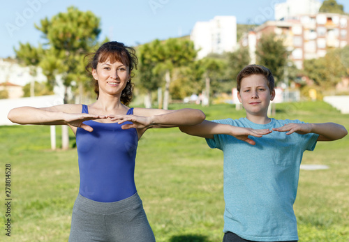 Mother and son stretching outdoors