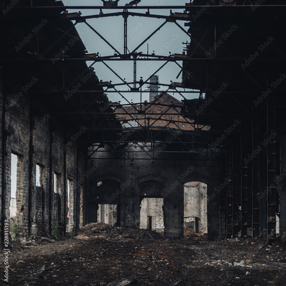 Fototapeta premium Interior of old factory buildings destroyed. Ruins of industrial enterprise, dark debris destroyed factory premises in factory as result of economic crisis and earthquake.