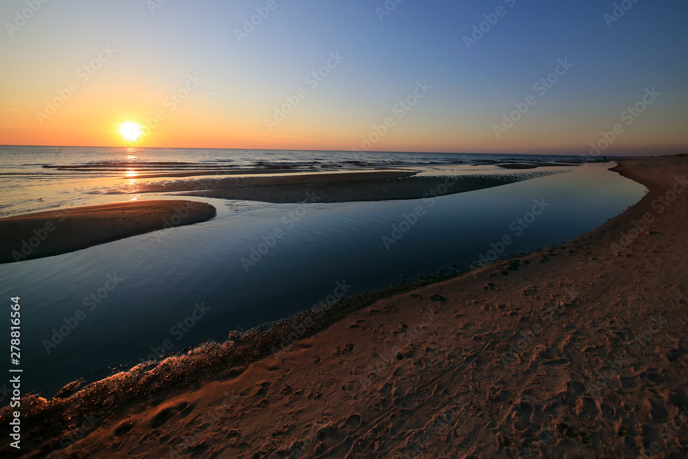 Sandy beach on the Baltic Sea on the Curonian Spit in Lithuania in the evening during sunset.