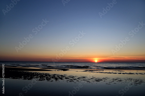 Sandy beach on the Baltic Sea on the Curonian Spit in Lithuania in the evening during sunset.