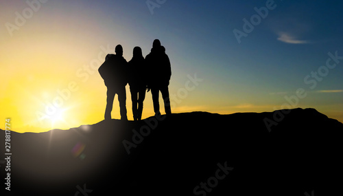 travel, tourism and hike concept - group of travellers with backpacks on mountain top over sunrise background