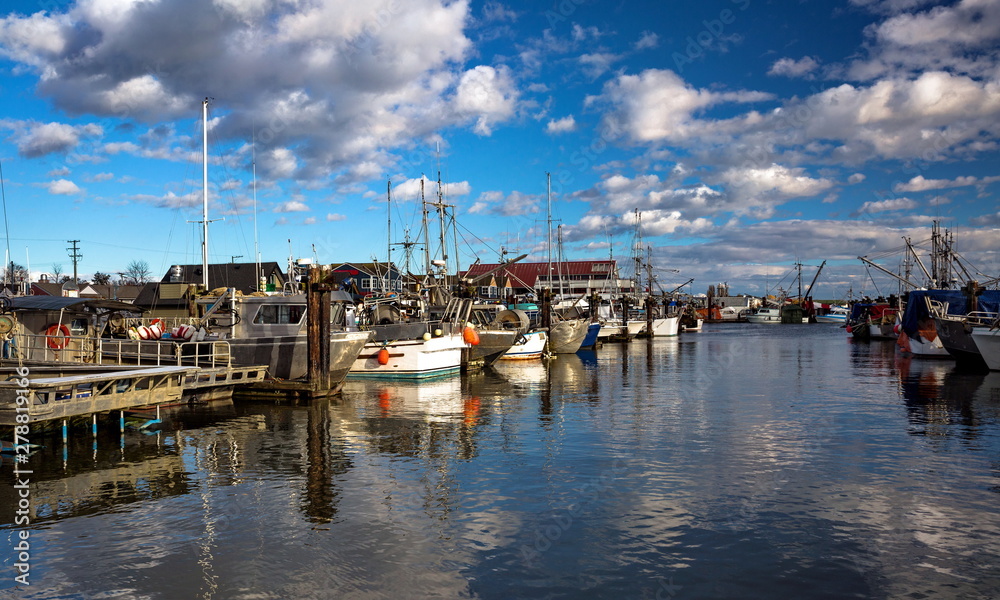 Fishing Boats in Marina and a cloudy sky. This marina is located in the Steveston area of Richmond. The fishing village formed in this place was the first settlement on the territory of  Richmond 