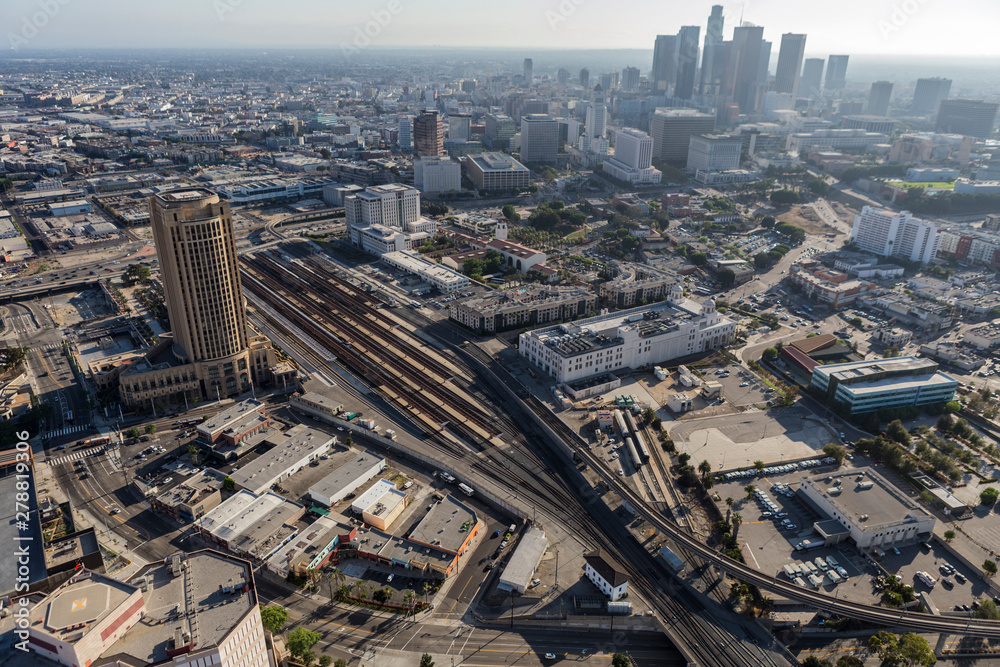 Aerial view of streets, buildings, transit train tracks, towers and homes in downtown Los Angeles California.