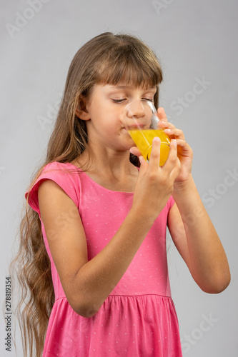 Girl drinking orange juice from a glass