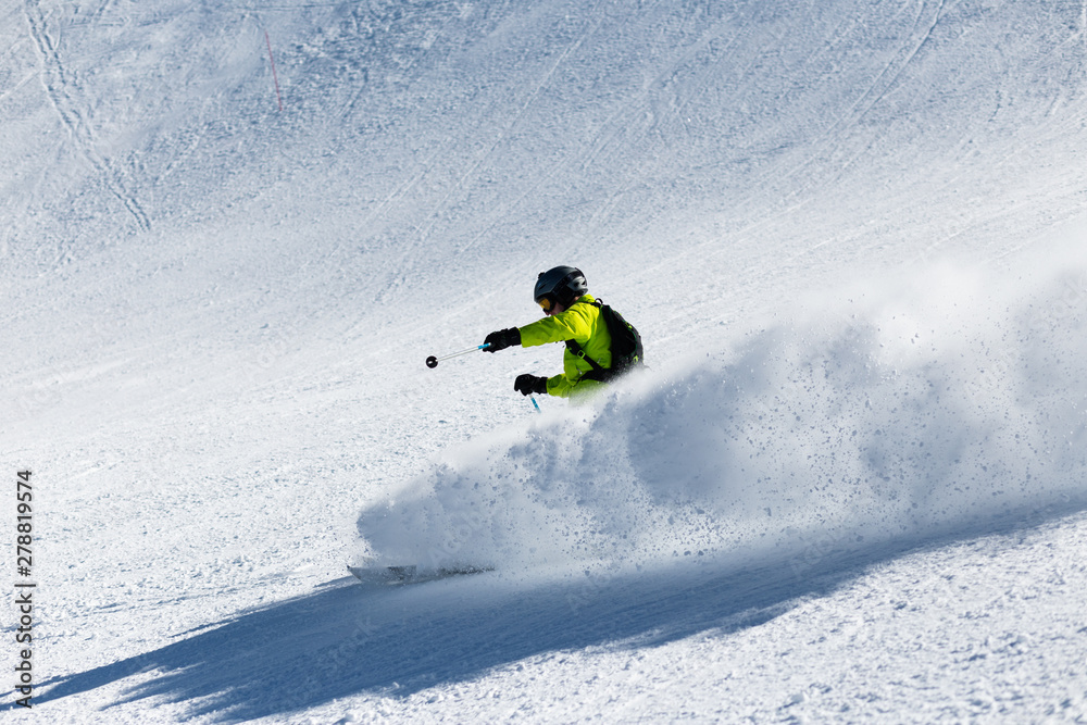 A skier at high speed descends from the mountain.