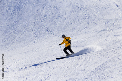 A skier at high speed descends from the mountain.