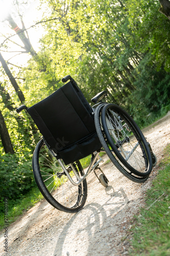 Empty wheelchair parked in park, health care concept