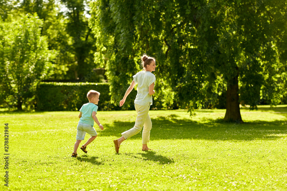 family, leisure and people concept - happy mother and little son running and playing catch game at summer park family, leisure and people concept - happy mother and little son running and playing catch game at summer park