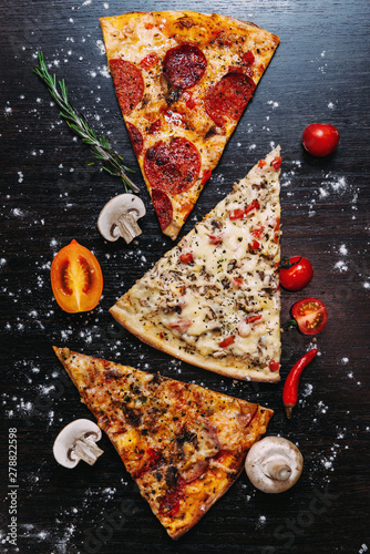 Slices of pizza with vegetables on a black background