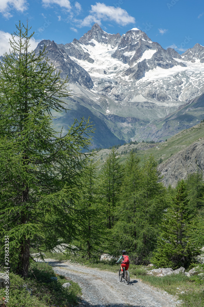 active senior woman, riding her electric mountainbike below the famous Matterhorn in Zermatt, Wallis,Switzerland active senior woman, riding her electric mountainbike below the famous Matterhorn in Zermatt, Wallis,Switzerland