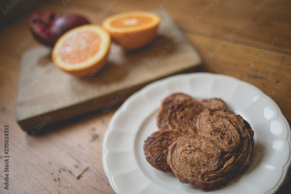 Breakfast time, table ready with sweets, orange and pomegranate. Morning and healthy lifestyle concept Breakfast time, table ready with sweets, orange and pomegranate. Morning and healthy lifestyle concept