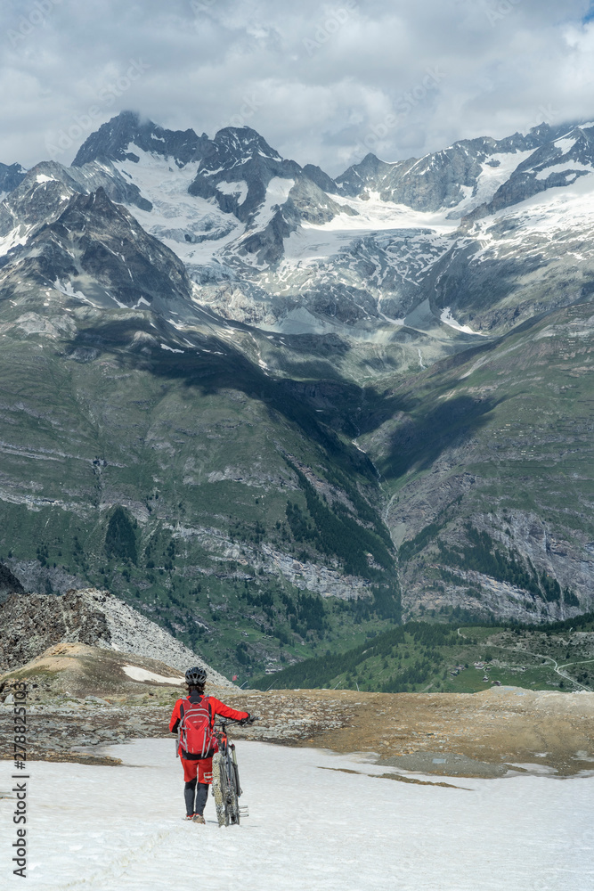 Fototapeta premium active senior woman, riding her electric mountainbike below the famous Matterhorn in Zermatt, Wallis,Switzerland