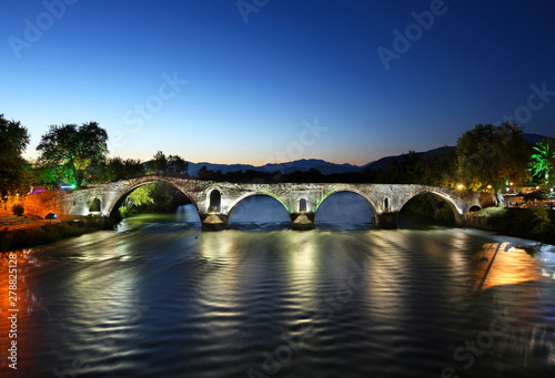 Night view of the legendary old stone arched bridge of Arta, crossing Arachthos river. Epirus, Greece. photo