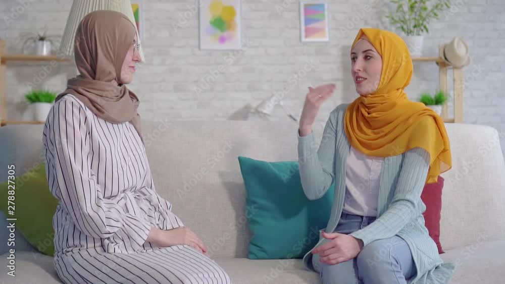 portrait two smiling beautiful deaf young Muslim women in hijabs ...