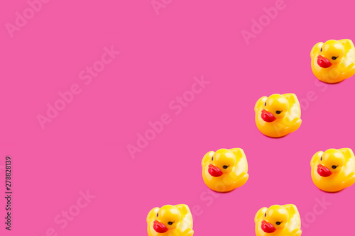 Yellow glamour rubber ducks with red lips pattern on pink background with copy space