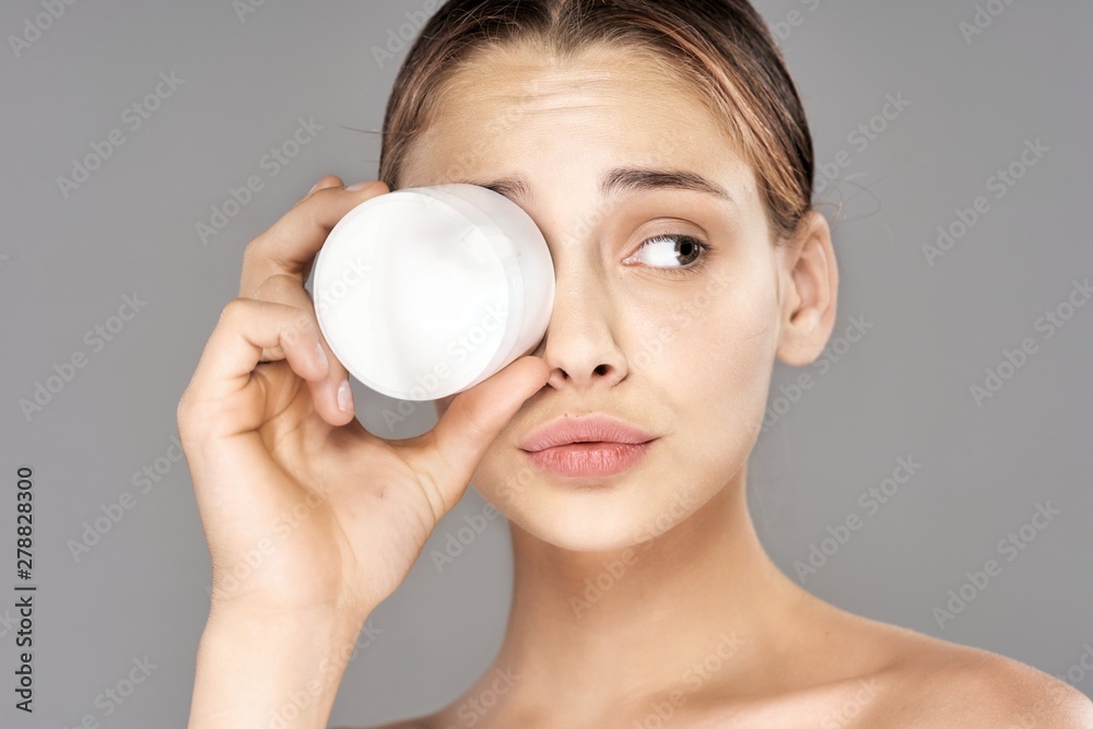 woman applying moisturizer cream on her face woman applying moisturizer cream on her face