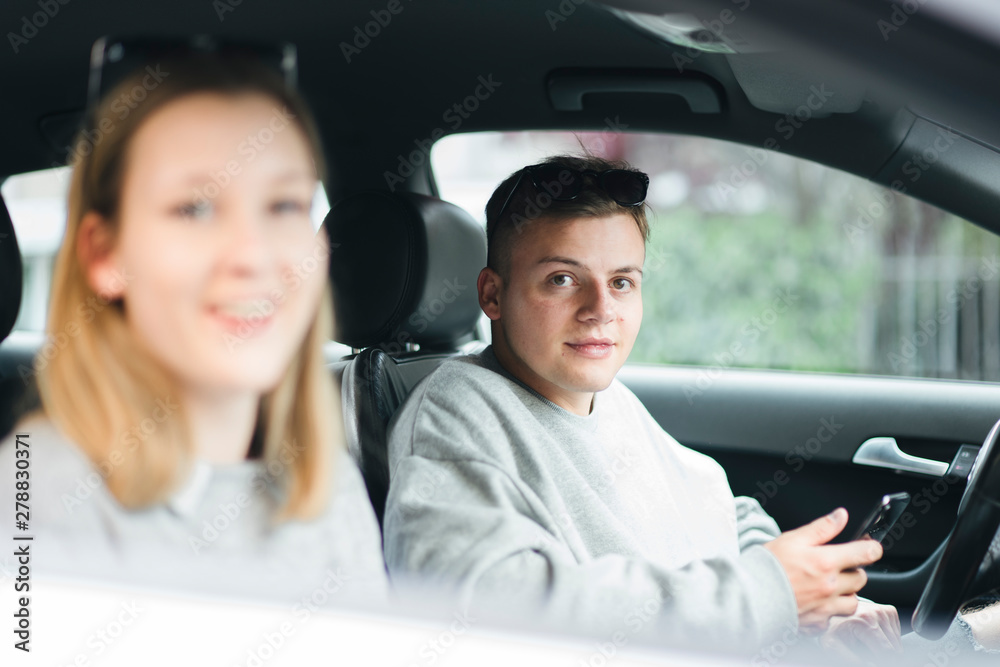 Portrait of young man with smartphone at driver's seat Portrait of young man with smartphone at driver's seat