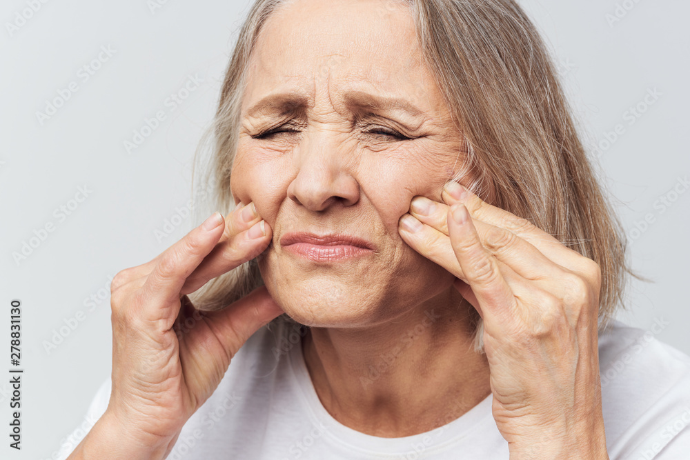 portrait of senior woman with hands on face portrait of senior woman with hands on face