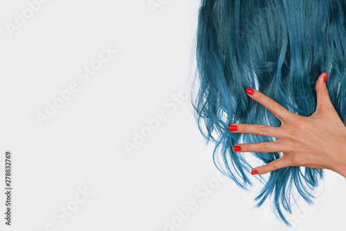 hand holding natural blue hair isolated on white background with copy space. 
