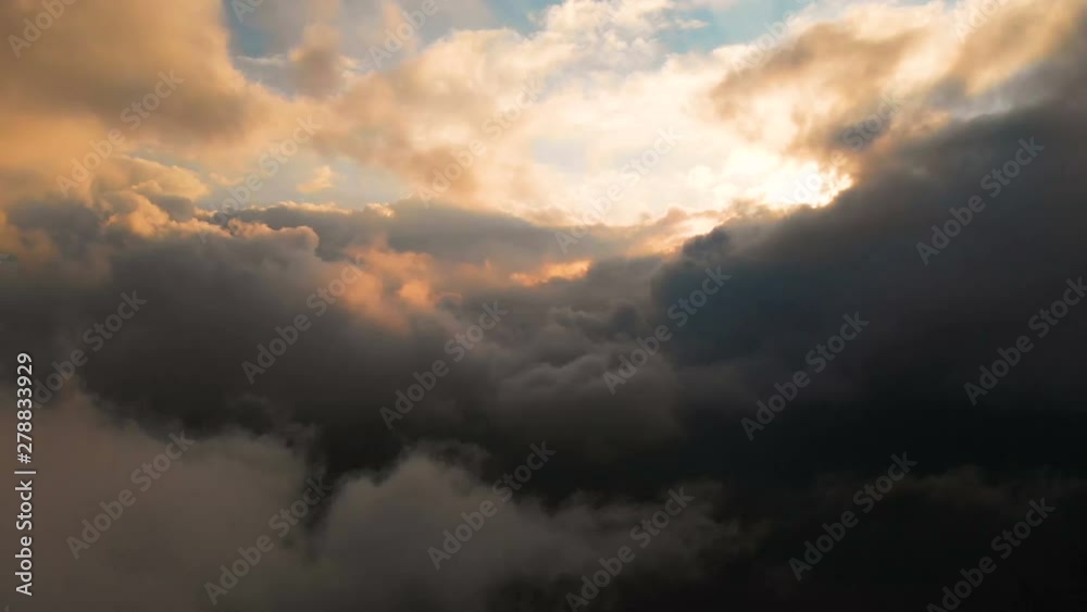 Span camera through the evening rain clouds at sunset above cloud levels. Fabulous flight in the clouds. Aerial view Span camera through the evening rain clouds at sunset above cloud levels. Fabulous flight in the clouds. Aerial view