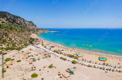 Aerial birds eye view drone photo Tsambika beach near Kolympia on Rhodes island, Dodecanese, Greece. Sunny panorama with sand beach and clear blue water. Famous tourist destination in South Europe © oleg_p_100
