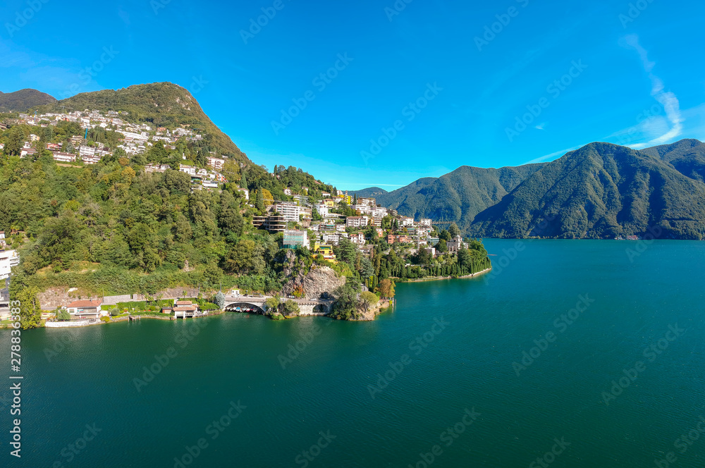 Panorama aerial view of the lake Lugano, mountains and city Lugano, Ticino canton, Switzerland. Scenic beautiful Swiss town with luxury villas. Famous tourist destination in South Europe