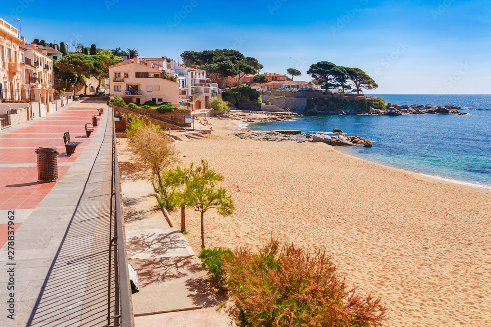 Obraz premium Promenade seafront in Calella de Palafrugell, Catalonia, Spain near Barcelona. Scenic village resort with nice sand beach and clear blue water in nice bay. Famous tourist destination in Costa Brava