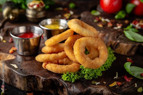 Delicious crunchy snack: chicken nuggets, french fries and breaded onion rings