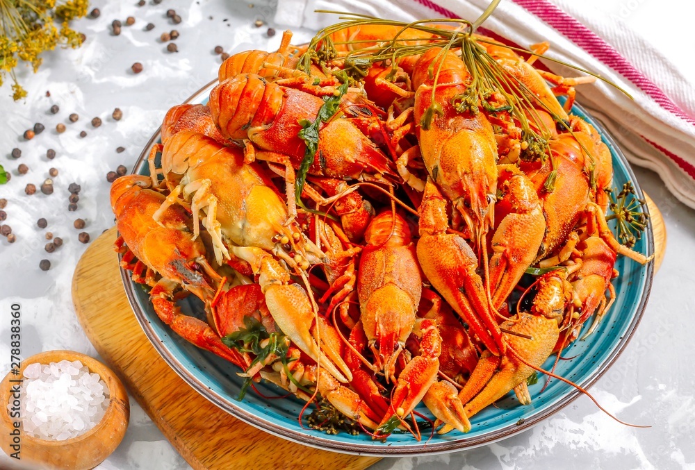Boiled crayfish with spices. Boiled crayfish on a plate, on a concrete background. Natural product.