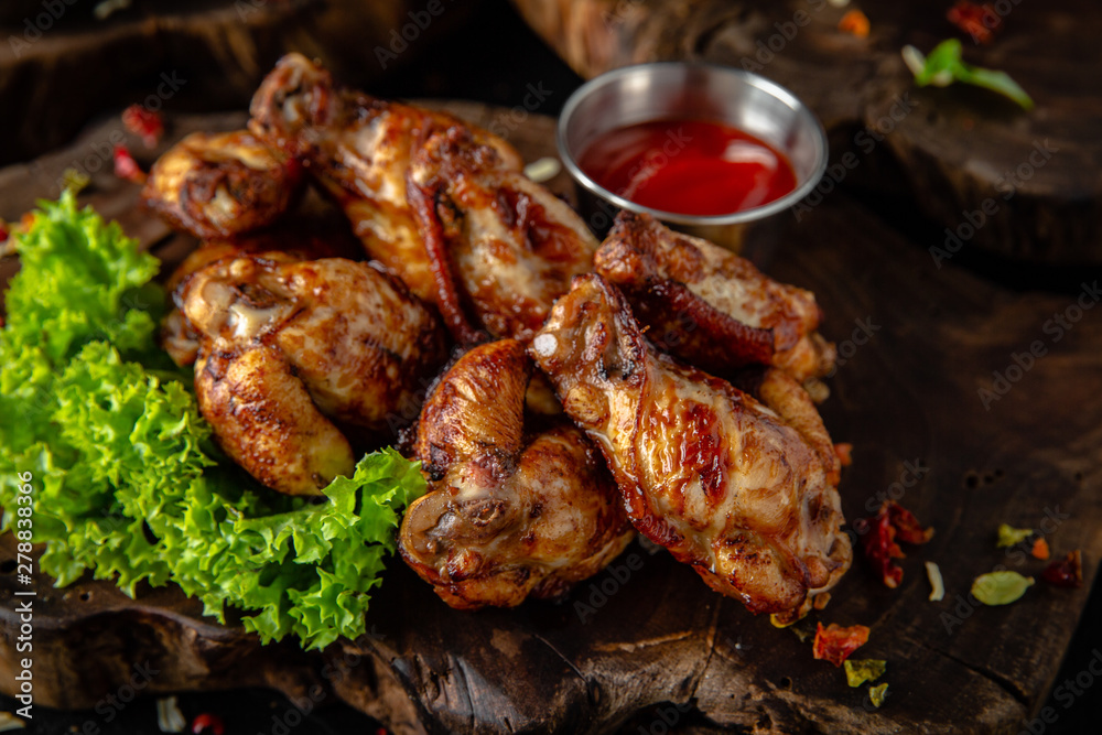 Juicy, crispy chicken wings breaded on wooden background, rustic style. Fast food 