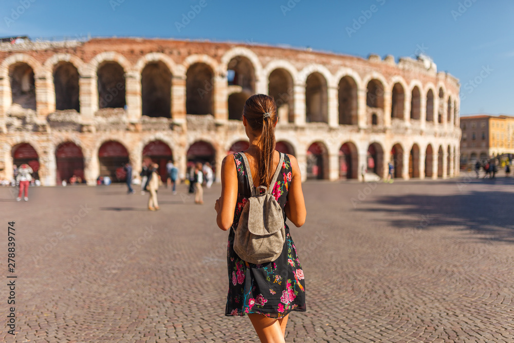Toirust woman in Verona historical center on square near Arena Verona, Roman amphitheater. Traveler in famous travel destination in Italy. Old town where lived Romeo and Juliet from Shakespeare story